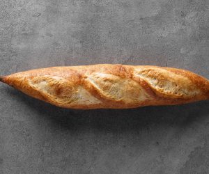 Rustic,Sourdough,Rye,Baguette,With,Cereal,On,A,Gray,Table,